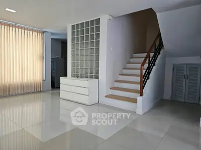 Spacious modern living area with staircase and large windows