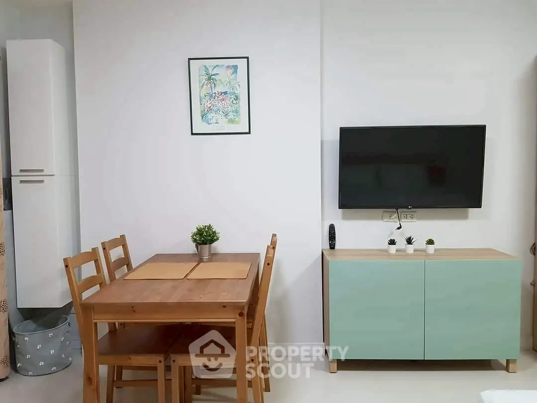 Modern living room with wooden dining set and wall-mounted TV, perfect for cozy gatherings.