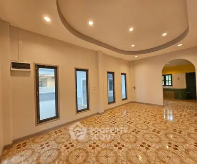 Spacious living room with elegant tiled flooring and modern recessed lighting.