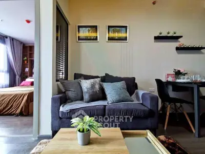 Modern living room with cozy sofa, stylish decor, and view into a bedroom, perfect for urban living.