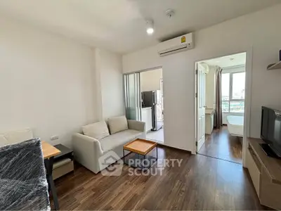 Modern living room with hardwood floors and natural light in a cozy apartment