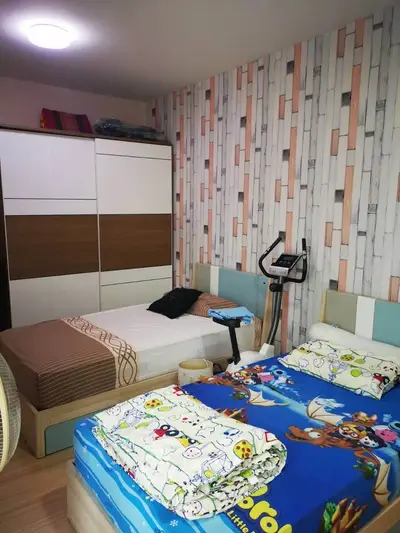 Cozy bedroom with twin beds and modern wardrobe, ideal for family living.