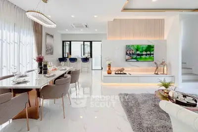 Luxurious open-plan living and dining area with modern decor and elegant lighting in a stylish home.