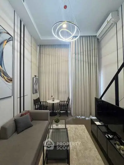 Modern living room with high ceilings, elegant lighting, and stylish decor in a luxury apartment.