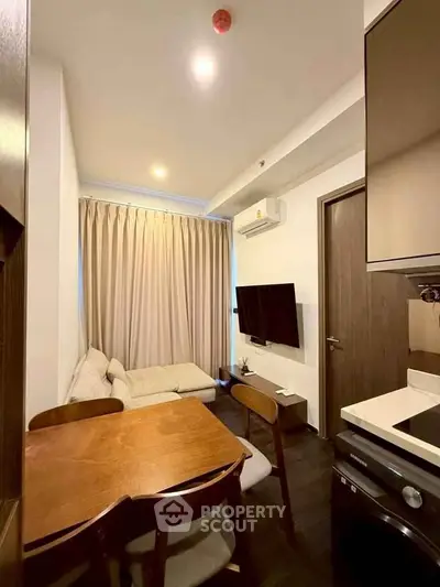 Cozy modern living room with stylish furniture and integrated kitchen appliances.