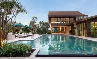 Luxurious modern villa with expansive pool and lush greenery, perfect for relaxation and entertainment.