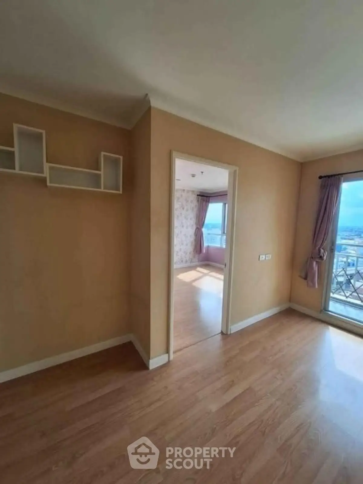 Spacious apartment with wooden flooring and large windows offering stunning city views.