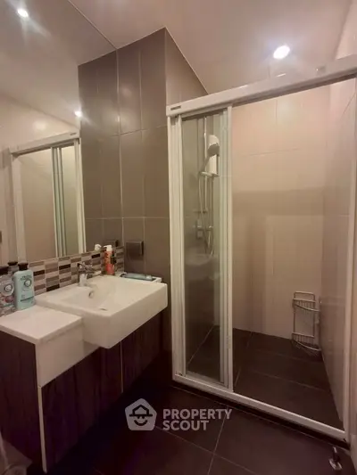 Modern bathroom with sleek shower and stylish sink in contemporary design.