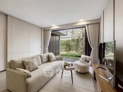Luxurious living room with modern decor and garden view, featuring a cozy sofa and sleek TV setup.