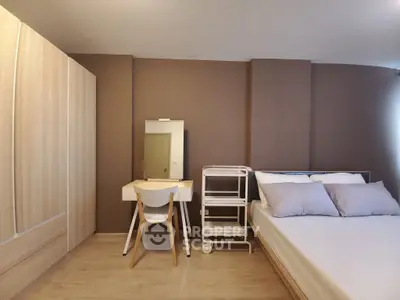 Modern bedroom with stylish furniture and neutral tones, featuring a cozy bed and a sleek vanity desk.