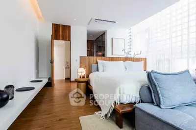 Luxurious modern bedroom with elegant wooden accents and cozy seating area.