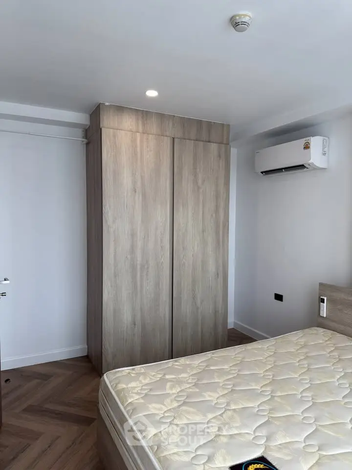 Modern bedroom with wooden wardrobe and air conditioning unit