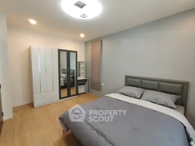 Spacious modern bedroom with stylish decor and ample storage in a contemporary apartment.