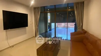 Spacious living room with modern decor and large sliding glass doors leading to a balcony.