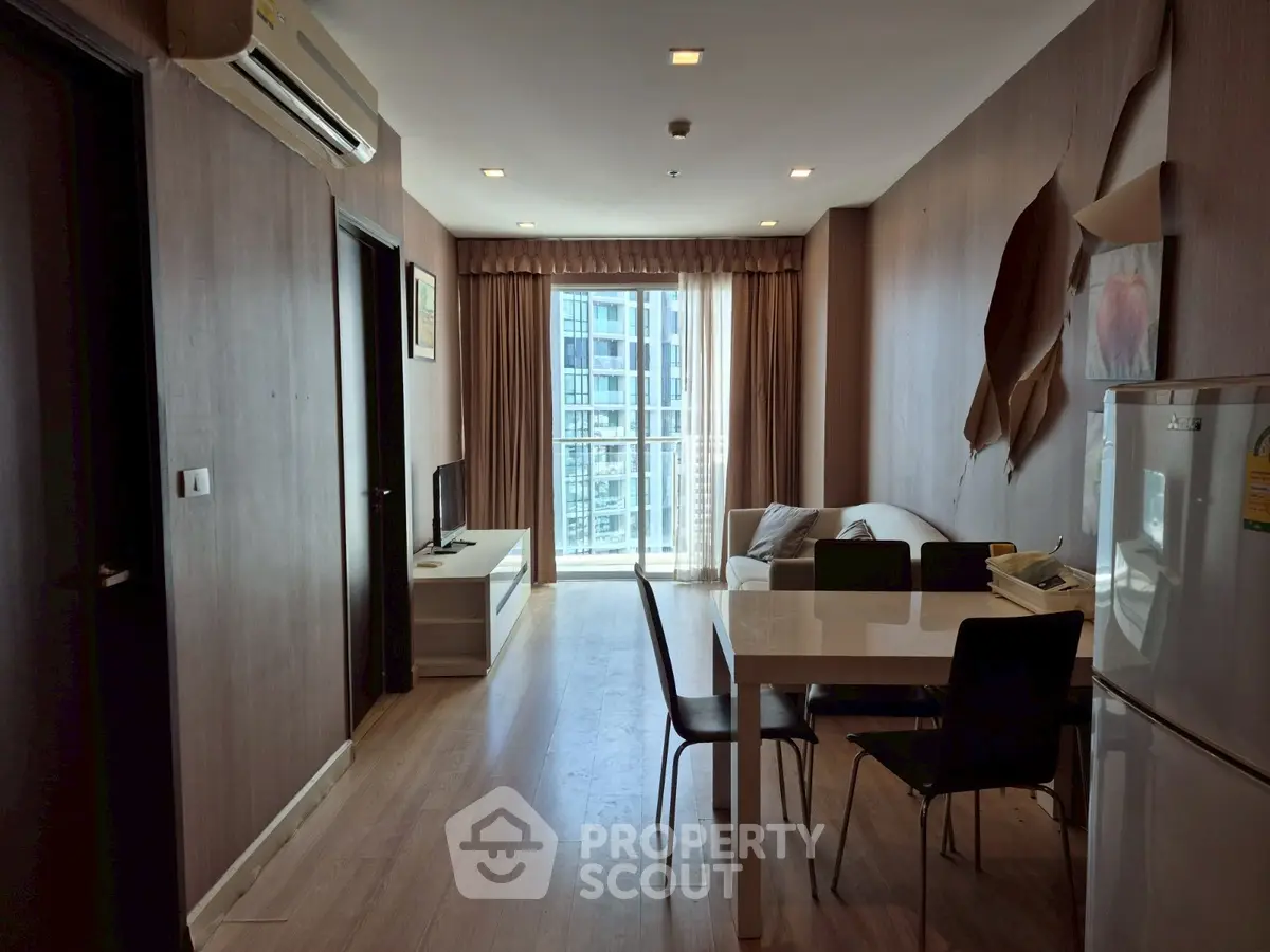 Modern living room with dining area and balcony view in a stylish apartment.