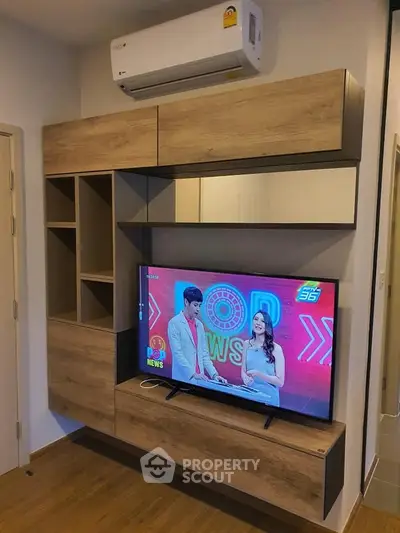 Modern living room with stylish wooden TV cabinet and mounted air conditioner.