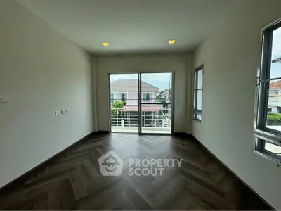 Spacious room with large windows and balcony access, offering abundant natural light and modern flooring.