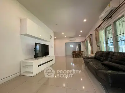 Spacious modern living room with sleek furniture and large windows for natural light.