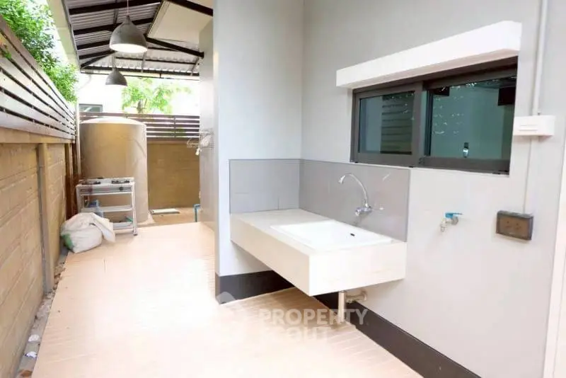 Modern outdoor utility area with sink and storage space, perfect for practical home tasks.