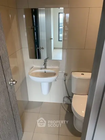 Modern compact bathroom with sleek fixtures and neutral tiles, perfect for urban living.