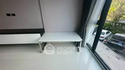 Modern minimalist interior with sleek white table and large window view