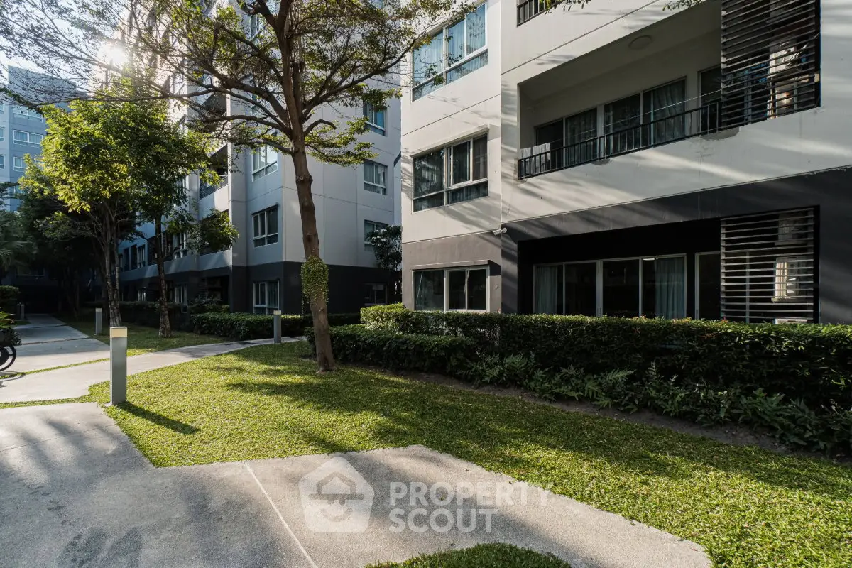 Modern apartment building exterior with lush greenery and pathway