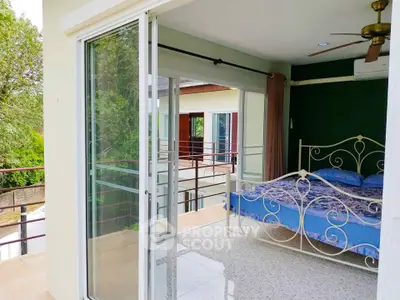 Spacious bedroom with balcony access and scenic view in modern home