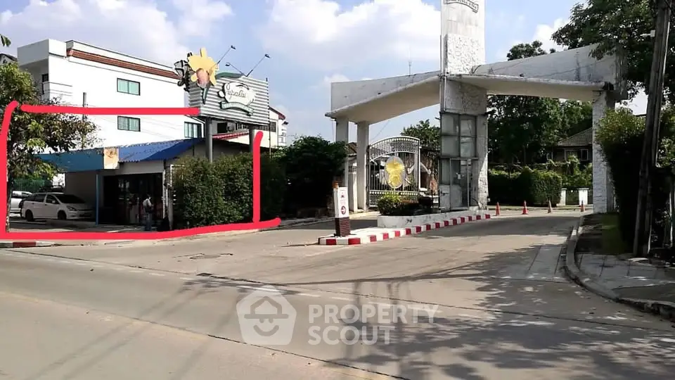 Charming gated community entrance with security booth and lush greenery.