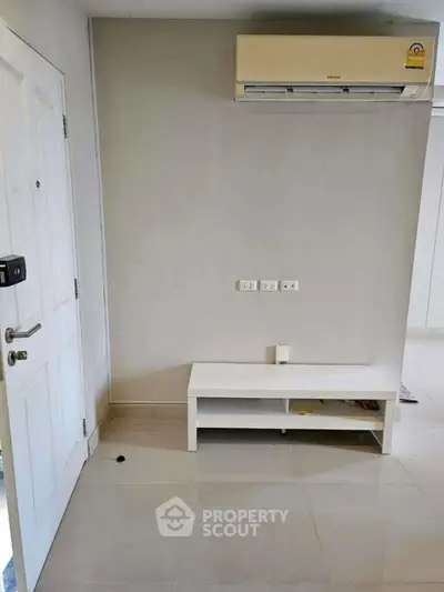 Minimalist interior with air conditioning and white furniture in modern apartment.