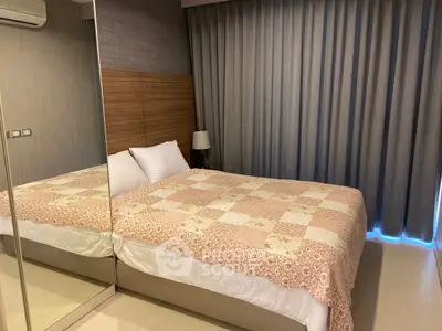 Cozy bedroom with mirrored closet and elegant curtains, perfect for relaxation.