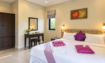Elegant bedroom with modern decor and cozy ambiance, featuring a stylish bed and a charming vanity area.