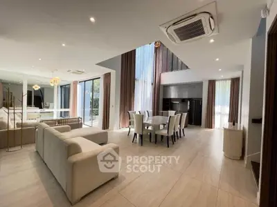 Luxurious open-plan living and dining area with modern furnishings and large windows.
