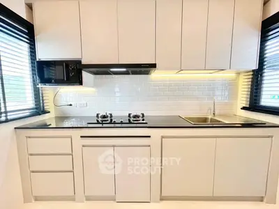 Modern kitchen with sleek cabinetry and gas stove in a bright, airy space.