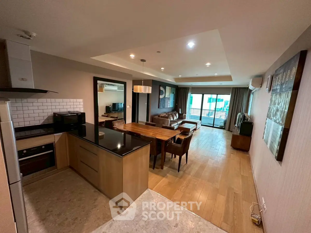 Spacious open-plan living room with modern kitchen and balcony view