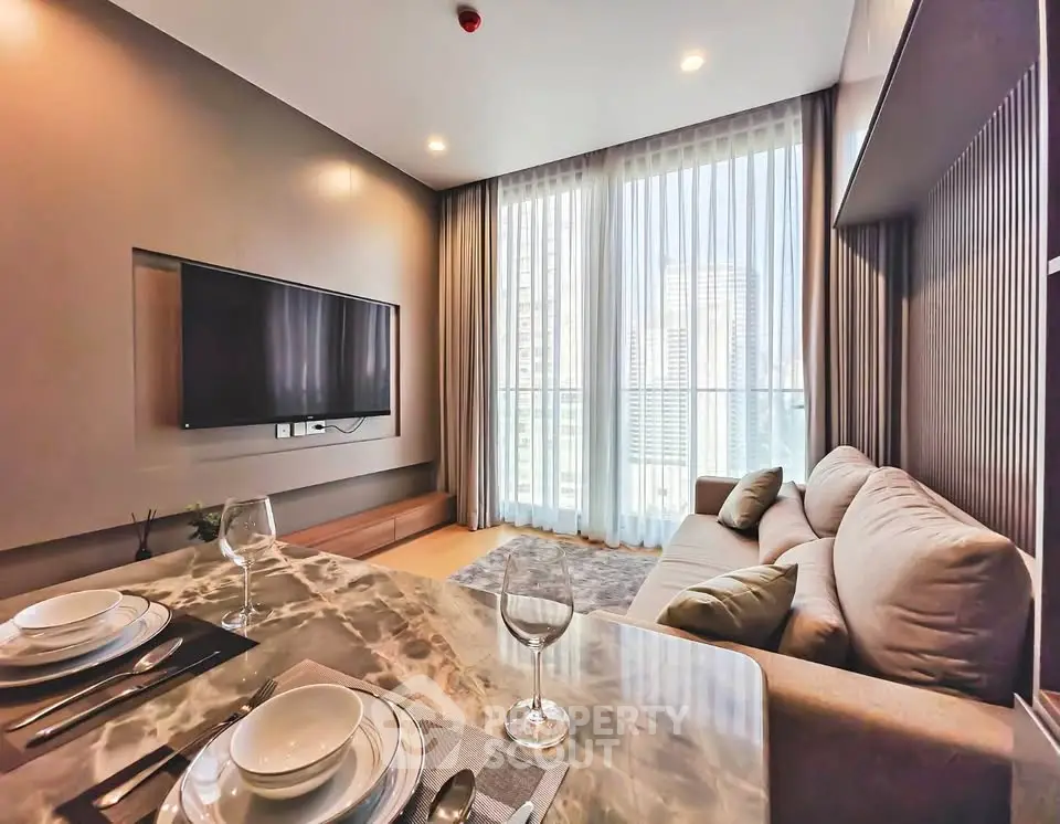 Modern living room with large windows and stylish decor in a high-rise apartment.