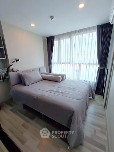 Modern bedroom with large windows and stylish decor in a contemporary apartment.