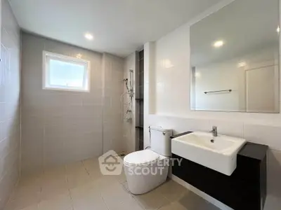 Spacious modern bathroom with sleek fixtures and ample natural light.