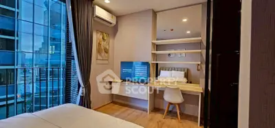 Modern bedroom with city view, featuring a sleek desk and mounted TV, perfect for urban living.