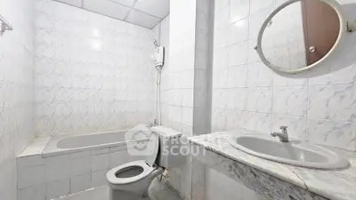 Spacious bathroom with bathtub and modern fixtures in a well-lit setting.