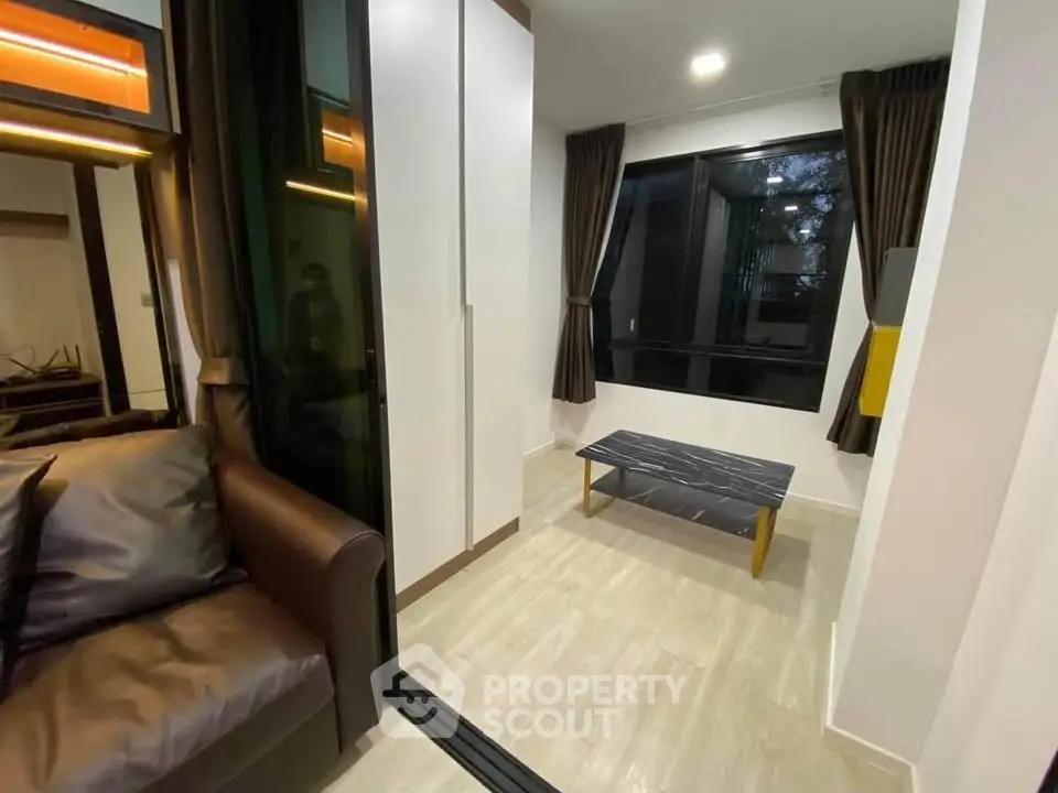 Modern living room with sleek design and large windows, featuring a cozy brown sofa and stylish coffee table.