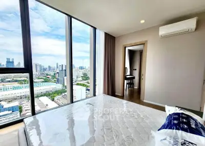 Luxurious bedroom with stunning city view and modern furnishings in high-rise apartment.
