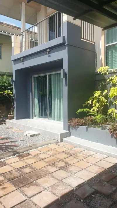 Charming modern home exterior with sliding glass doors and balcony, perfect for outdoor relaxation.