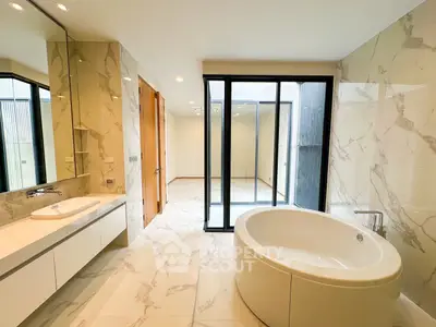 Luxurious bathroom with elegant marble tiles and modern oval bathtub