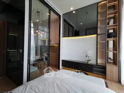 Modern bedroom with sliding glass doors, stylish shelving, and cozy lighting in a contemporary apartment.