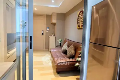 Modern apartment interior with cozy living area and sleek kitchen appliances.
