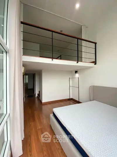 Modern loft bedroom with mezzanine and wooden flooring