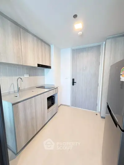 Modern kitchen with sleek cabinetry and stainless steel appliances in a stylish apartment.