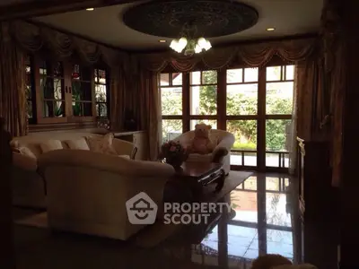 Luxurious living room with elegant furniture and large windows overlooking garden