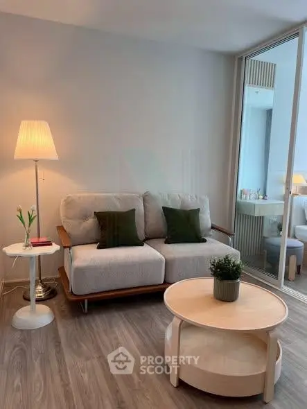 Modern living room with cozy sofa, stylish lamp, and elegant coffee table in a bright apartment.