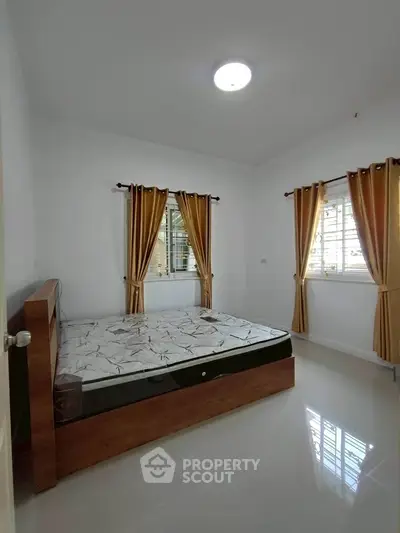 Spacious bedroom with natural light and modern furnishings, ideal for comfort and relaxation.